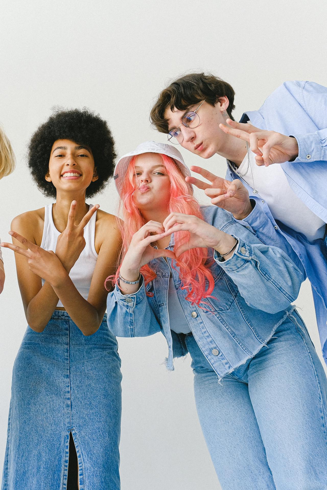 3 pessoas da jovens, fazendo gestos com as mãos para foto. Geração Z redefinindo o conceito de beleza.