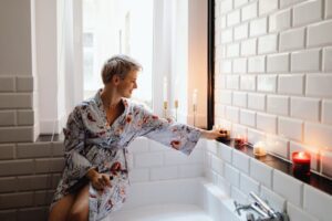 Guia completo do autocuidado, mulher acendo sua vela para um banho relaxante.